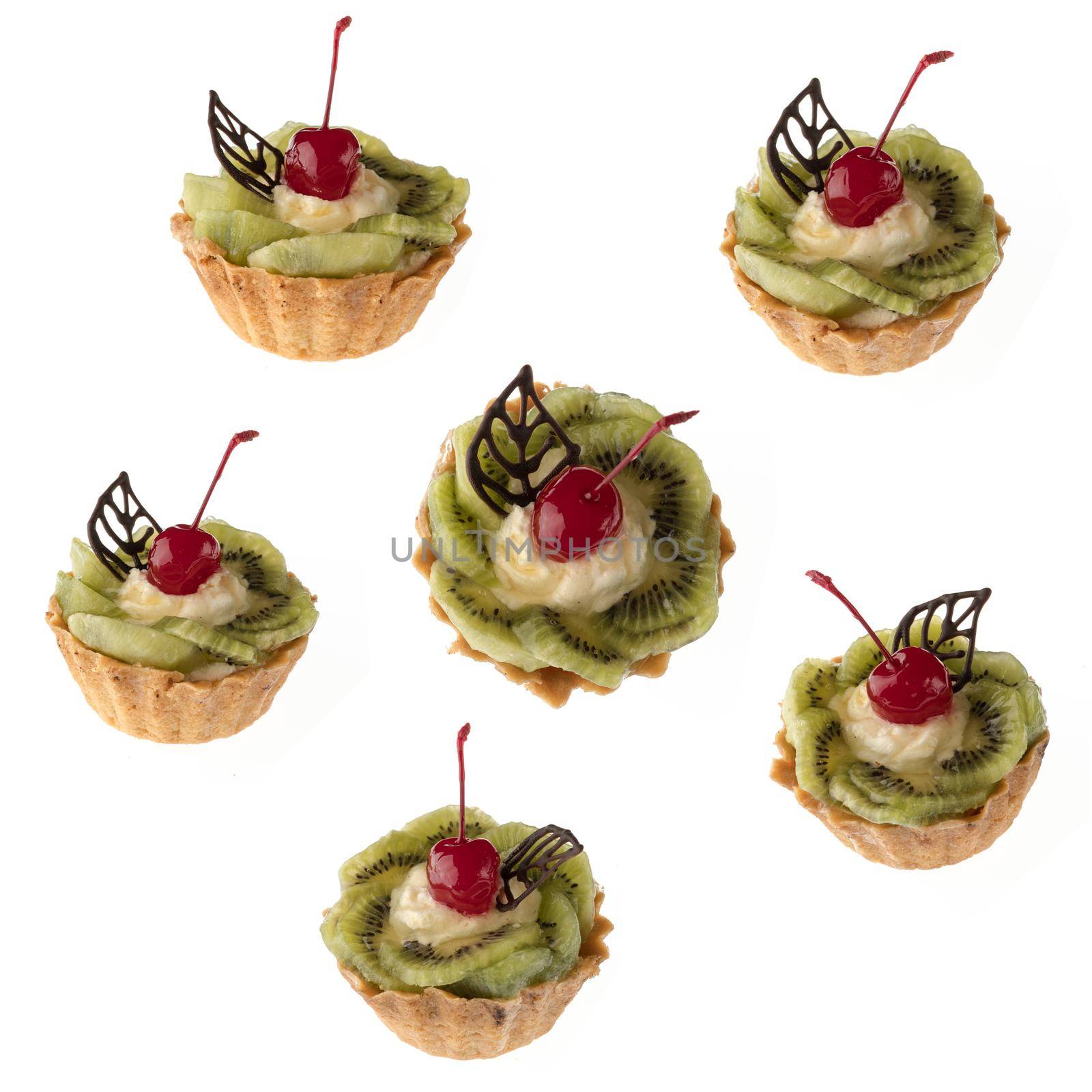 Dessert, cake with kiwi and cherries on a white plate isolated