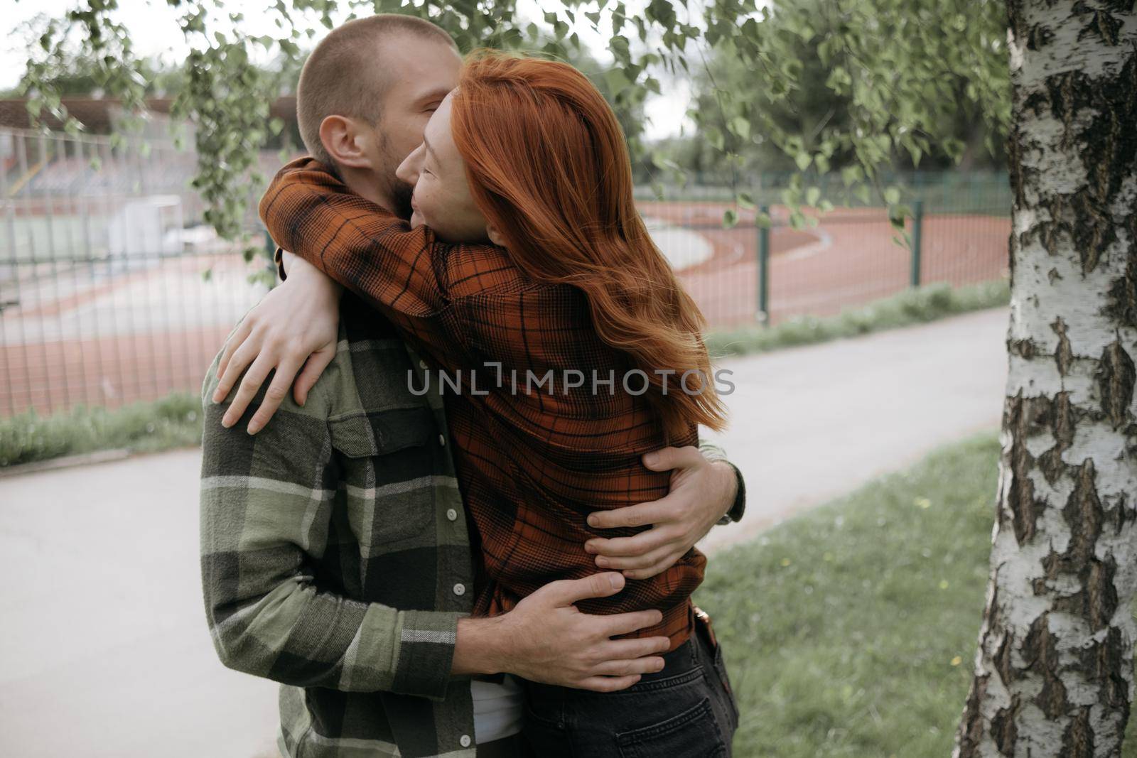 a loving couple hugs tightly on the street by Symonenko