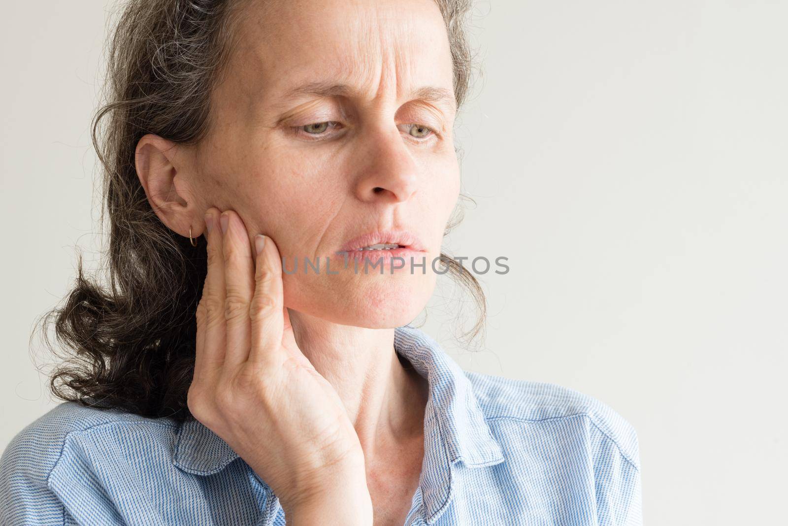 Close up of middle aged woman rubbing side of face