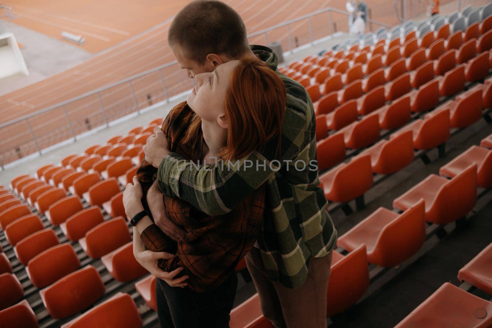 loved ones hug standing in the stadium stand
