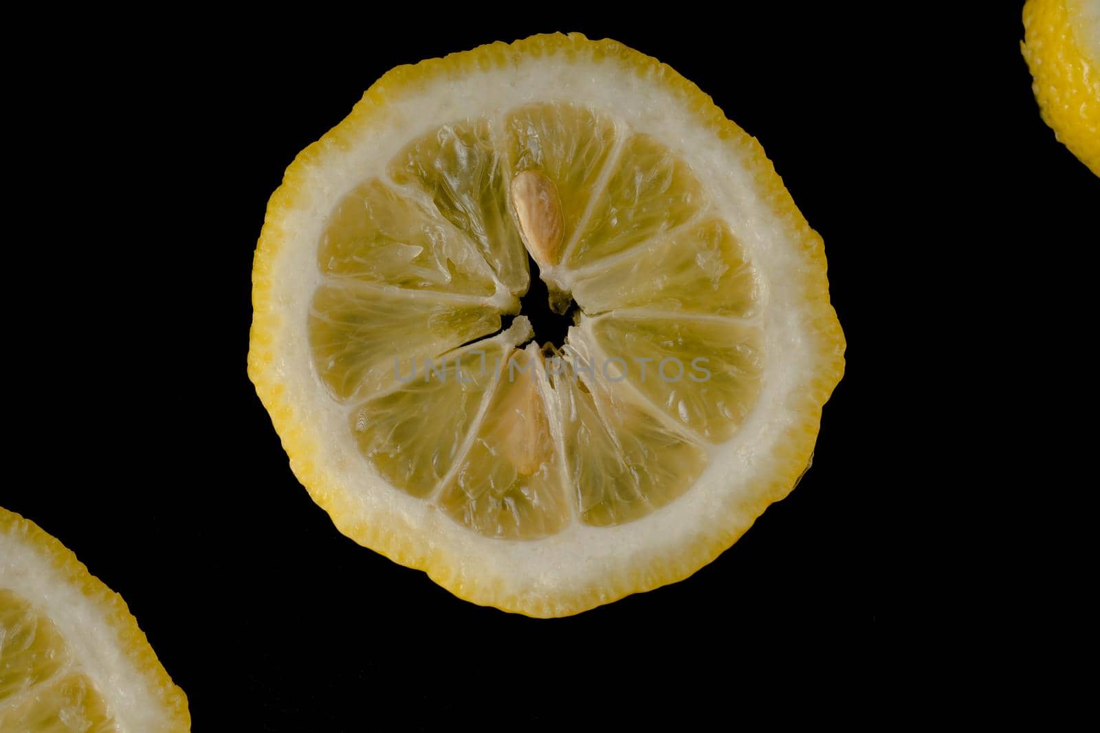 Five lemon slices lined up in a semicircle on a black background isolated by A_A