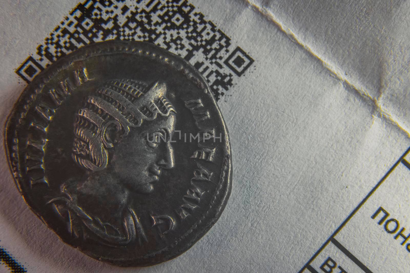 old coin on a sheet of paper with a cuar code close up