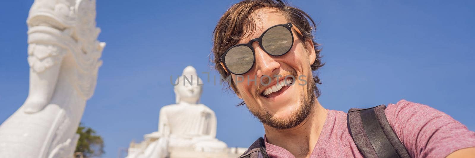 Man tourist on background of Big Buddha statue Was built on a high hilltop of Phuket Thailand Can be seen from a distance BANNER, LONG FORMAT by galitskaya