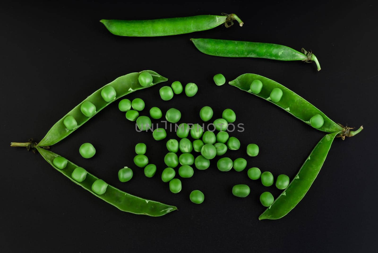 Peas in pods and green grains, on a black background