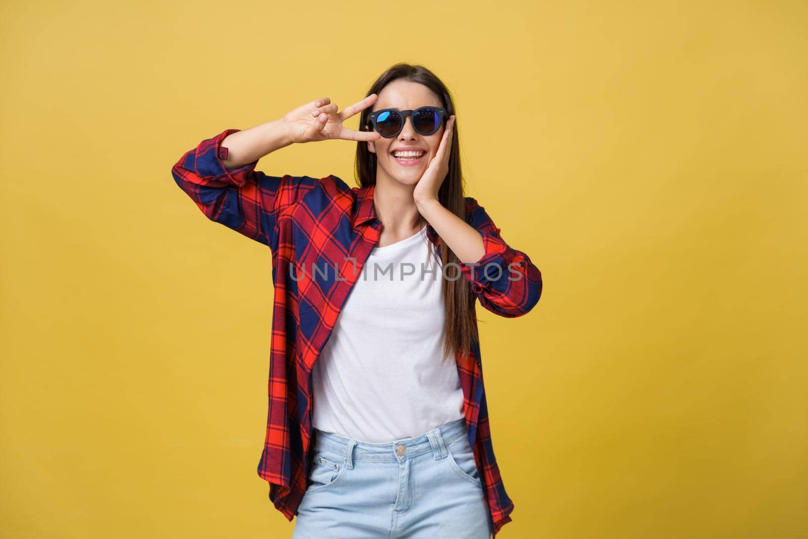 Open mouth people entertainment concept. Close up portrait of playful excited funny joyful positive optimistic with toothy smile girl showing v-sign isolated on yellow background copy space.