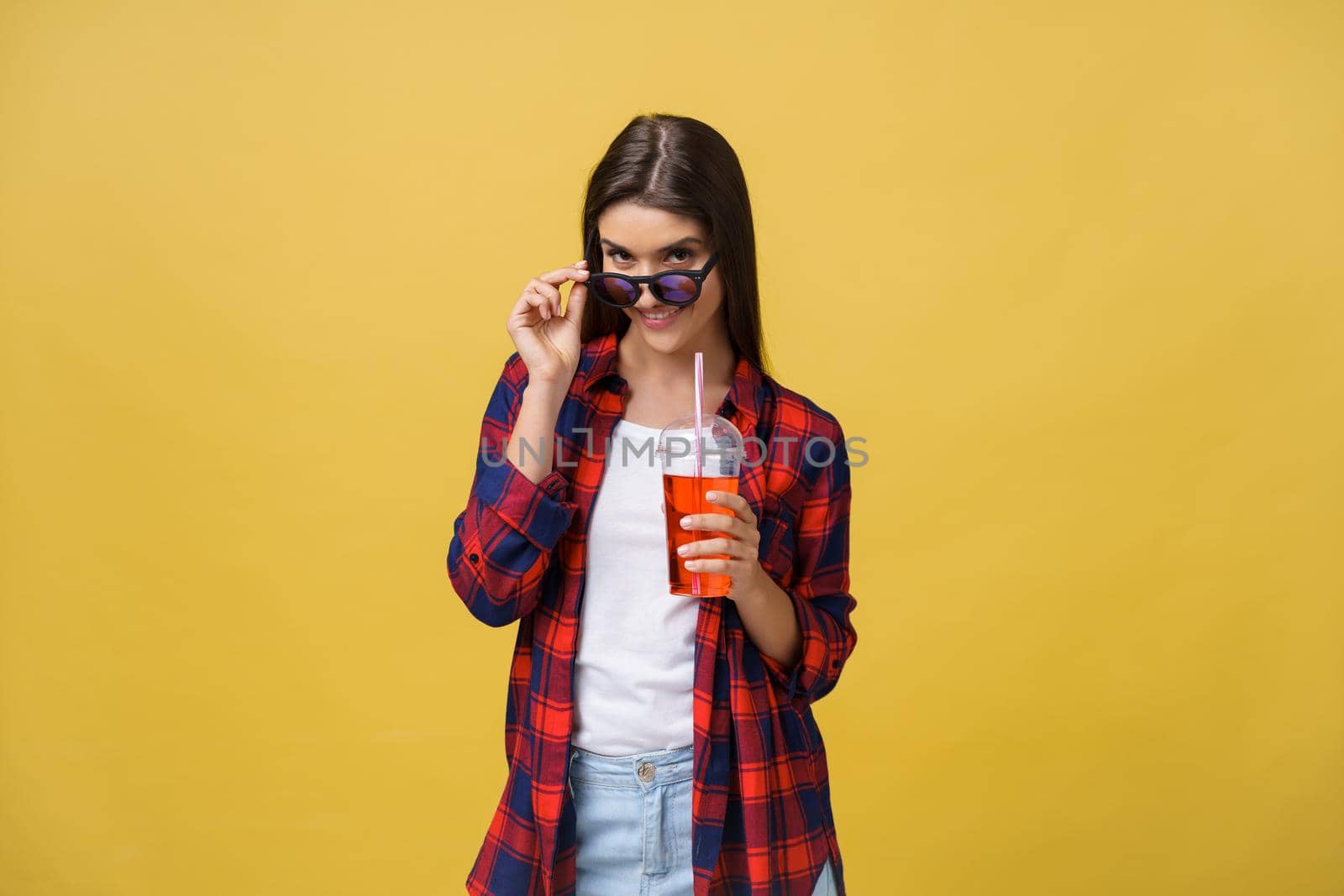 Young woman holding and drinking cold drink beverage in casual clothes. pretty girl smiling happy laughing looking at camera