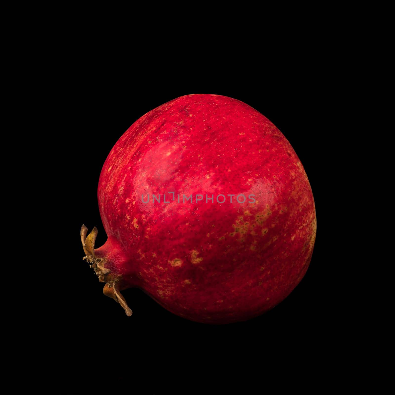 ripe whole pomegranate, on black background, isolated