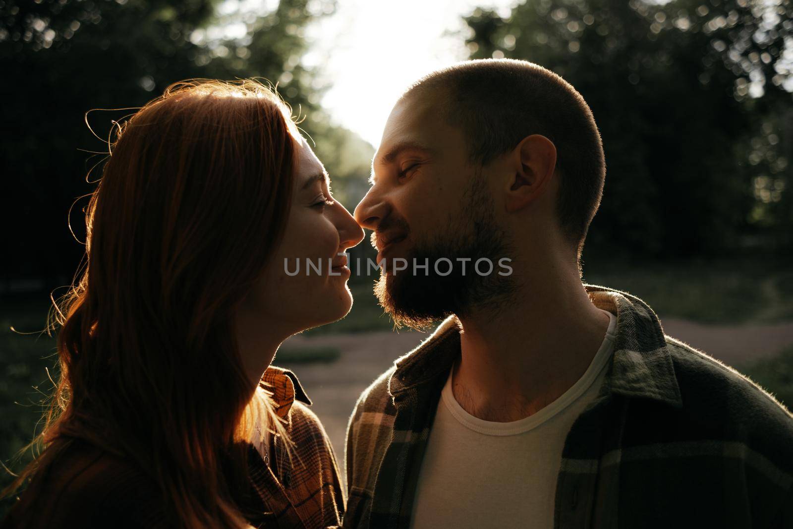 lovers kiss at sunset in the backlight
