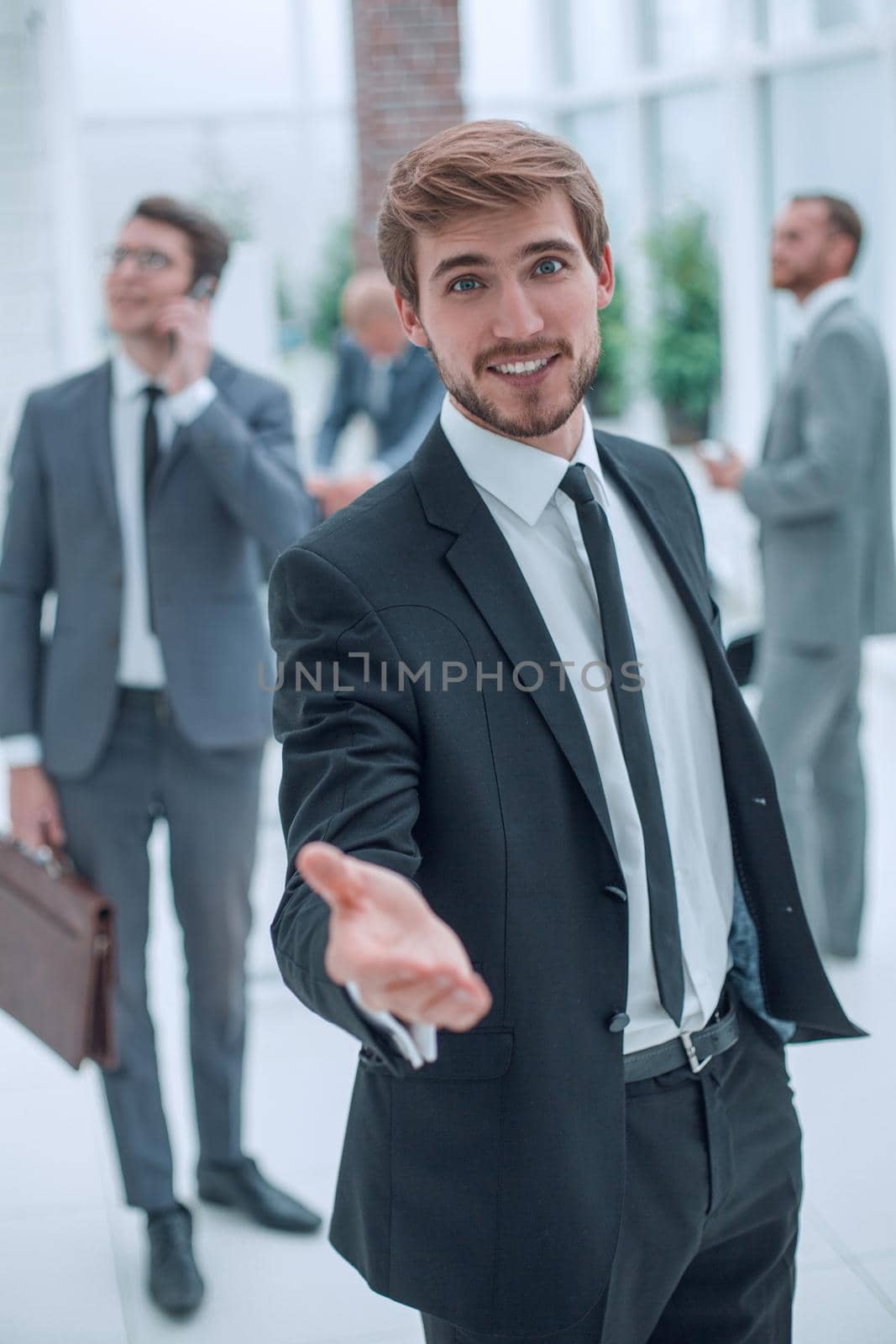 smiling business man holding out his hand for a handshake. concept of cooperation