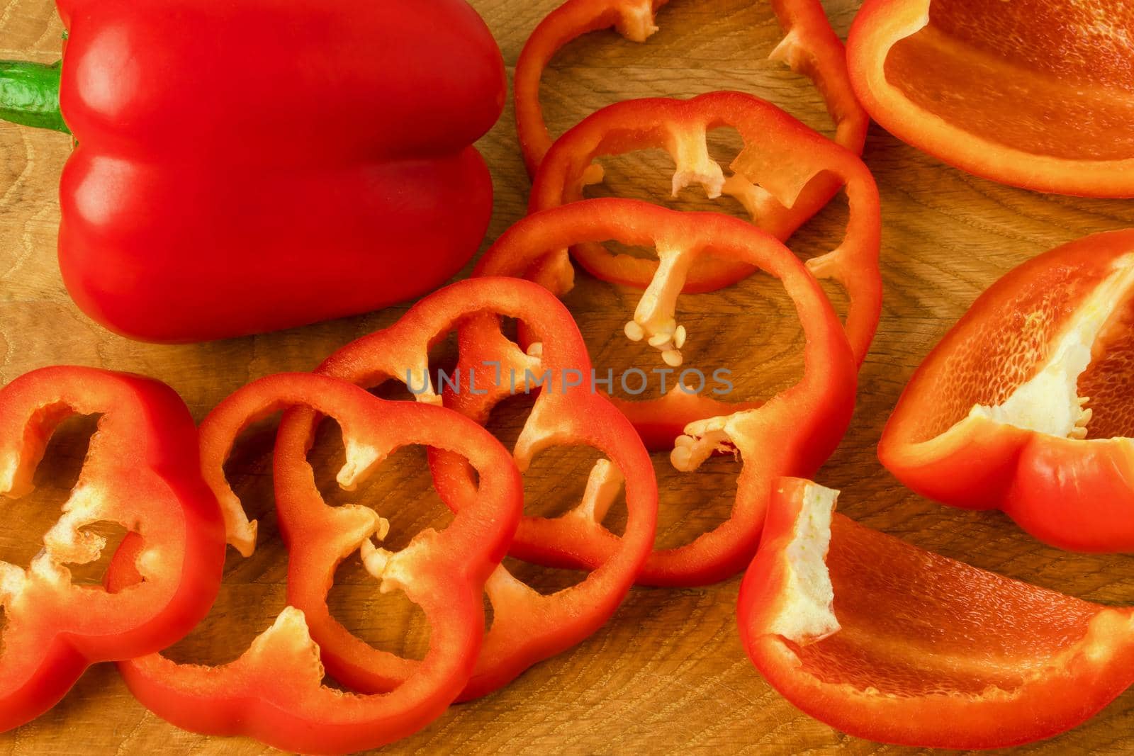 Sweet pepper whole and slices on a wooden board by A_A