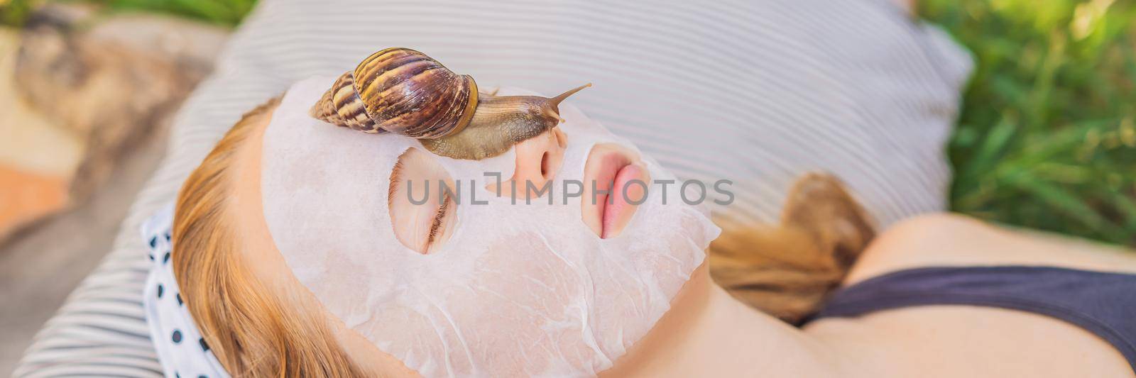 Young woman makes a face mask with snail mucus. Snail crawling on a face mask. BANNER, LONG FORMAT