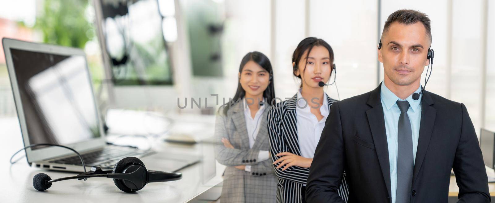 Business people wearing headset working in office to support remote customer or colleague. Call center, telemarketing, customer support agent provide service in broaden view .