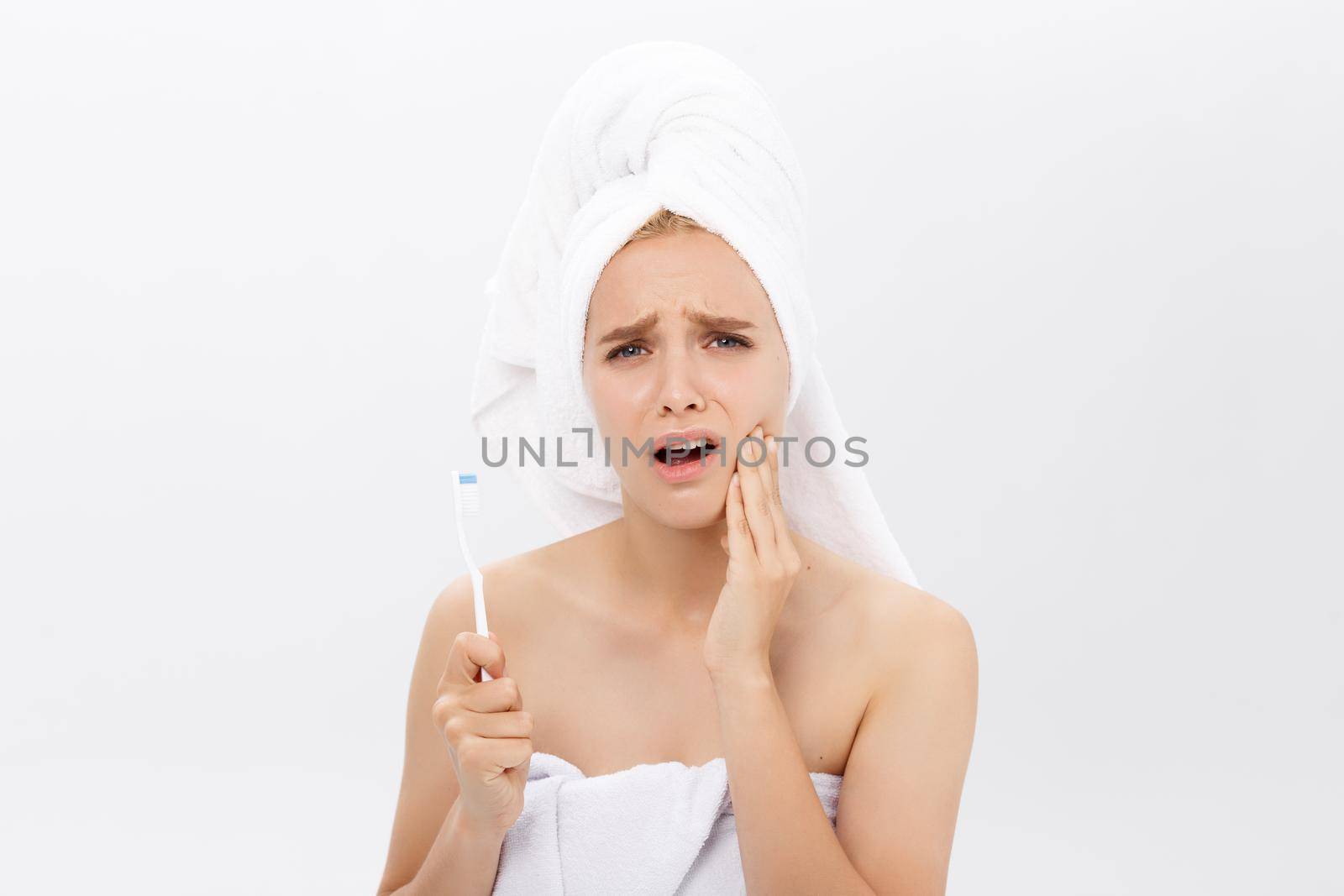 Young caucasian woman with toothache while brushing her teeth by Benzoix