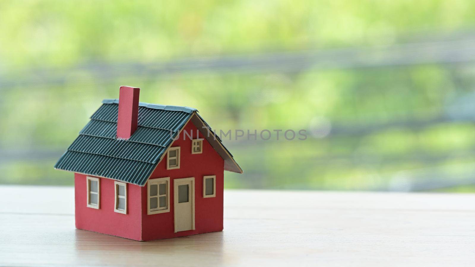 Close up a house model on wooden table. New house, insurance and real estate concept.