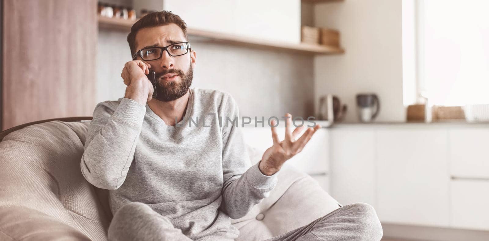 cheerful man talking on a mobile phone sitting in a comfortable chair. photo with copy space