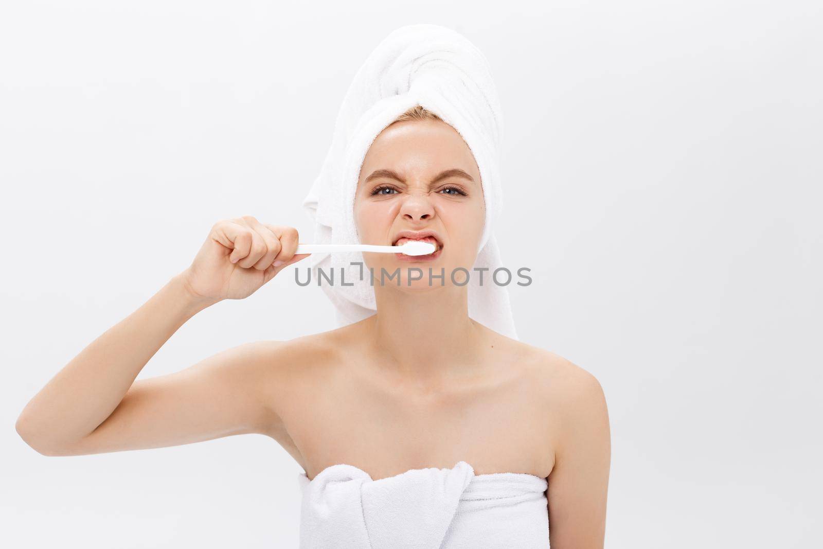 portrait of attractive caucasian smiling woman isolated on white studio shot head and shoulders face skin hand with tooth brush.