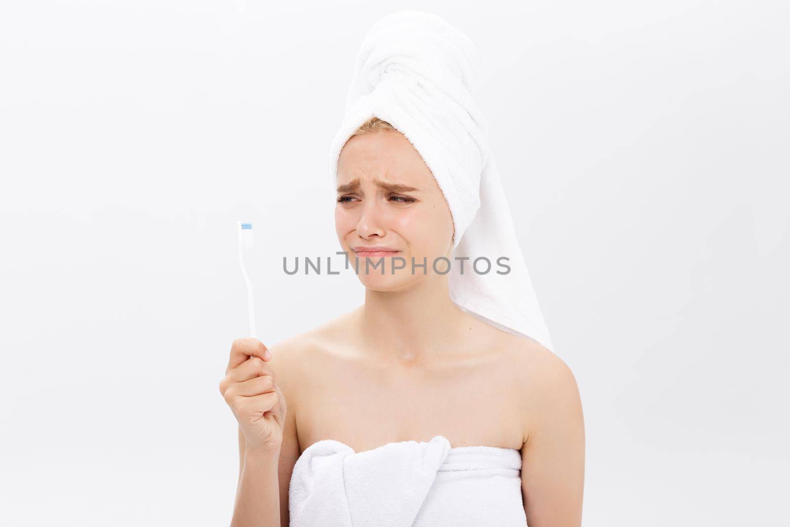 Sad young beautiful woman holding a toothbrush with disappointed facial expression. by Benzoix