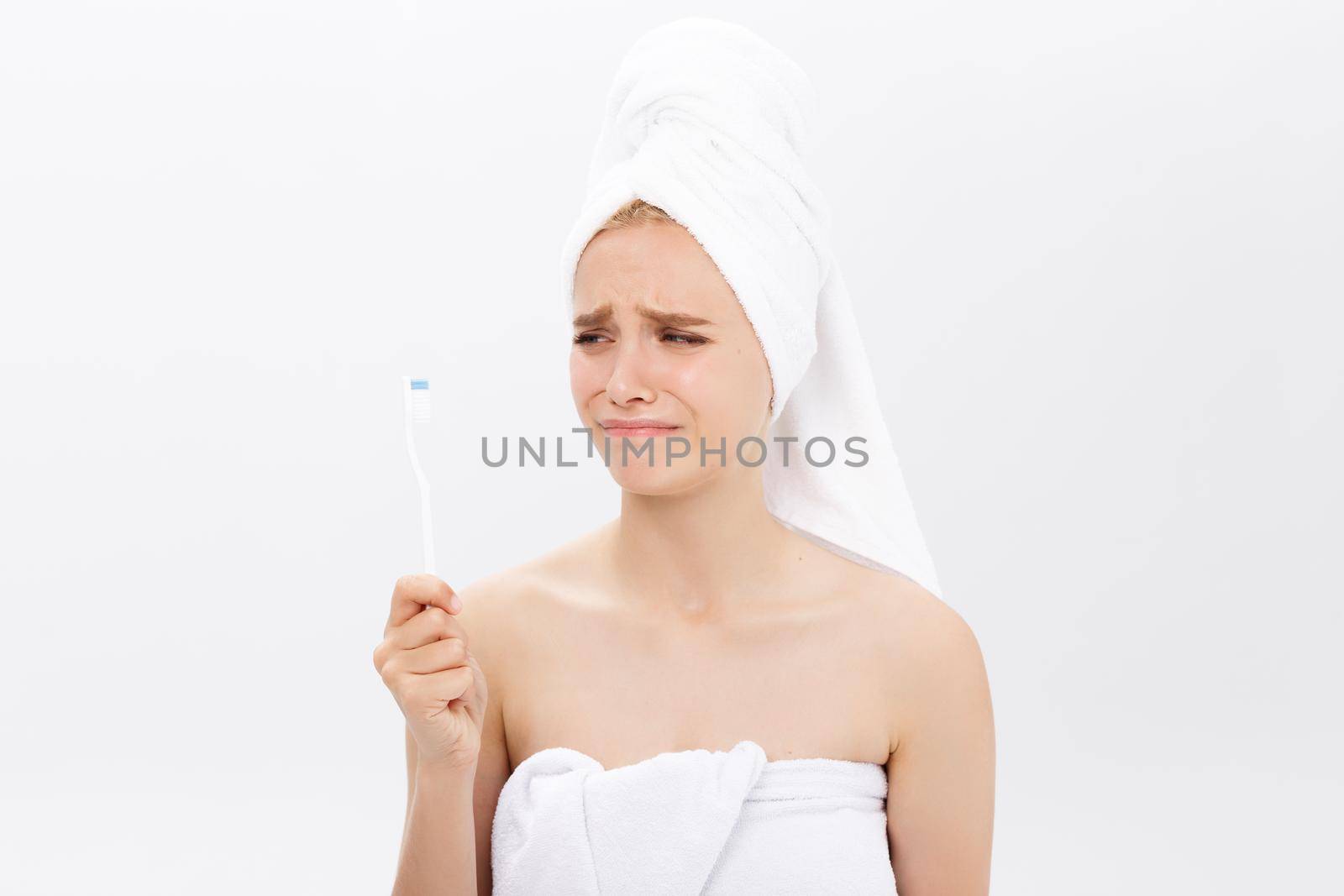 Sad young beautiful woman holding a toothbrush with disappointed facial expression