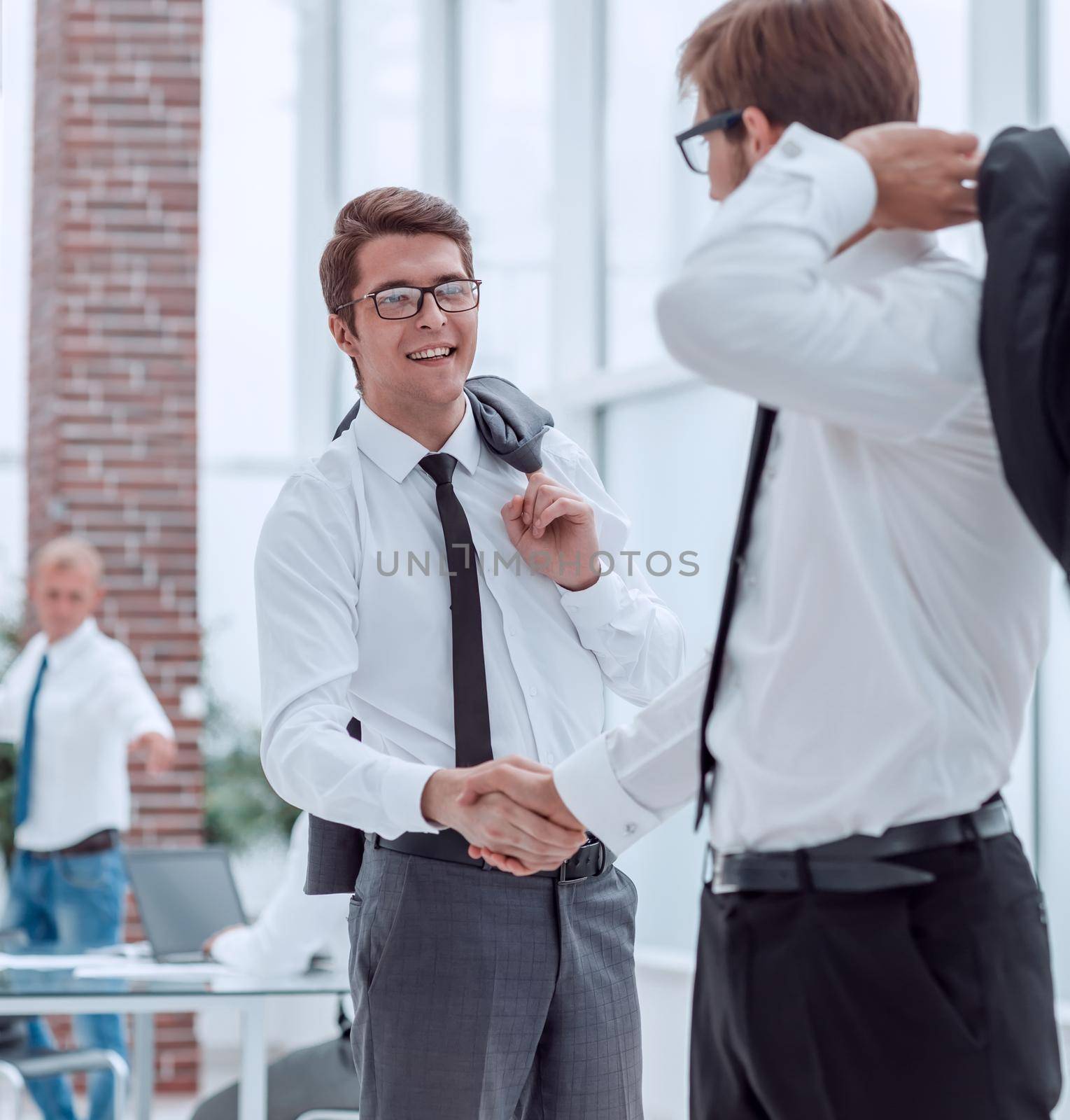 employees of the company greeting each other with a handshake. by asdf