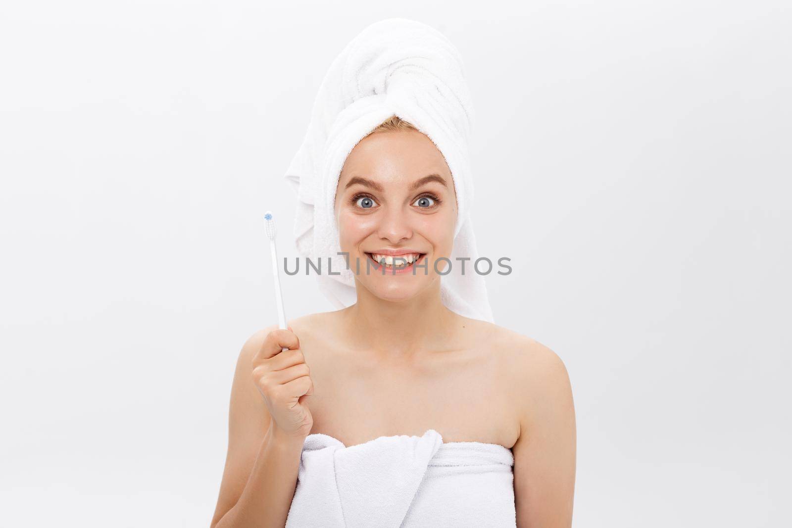 portrait of attractive caucasian smiling woman isolated on white studio shot head and shoulders face skin hand with tooth brush.