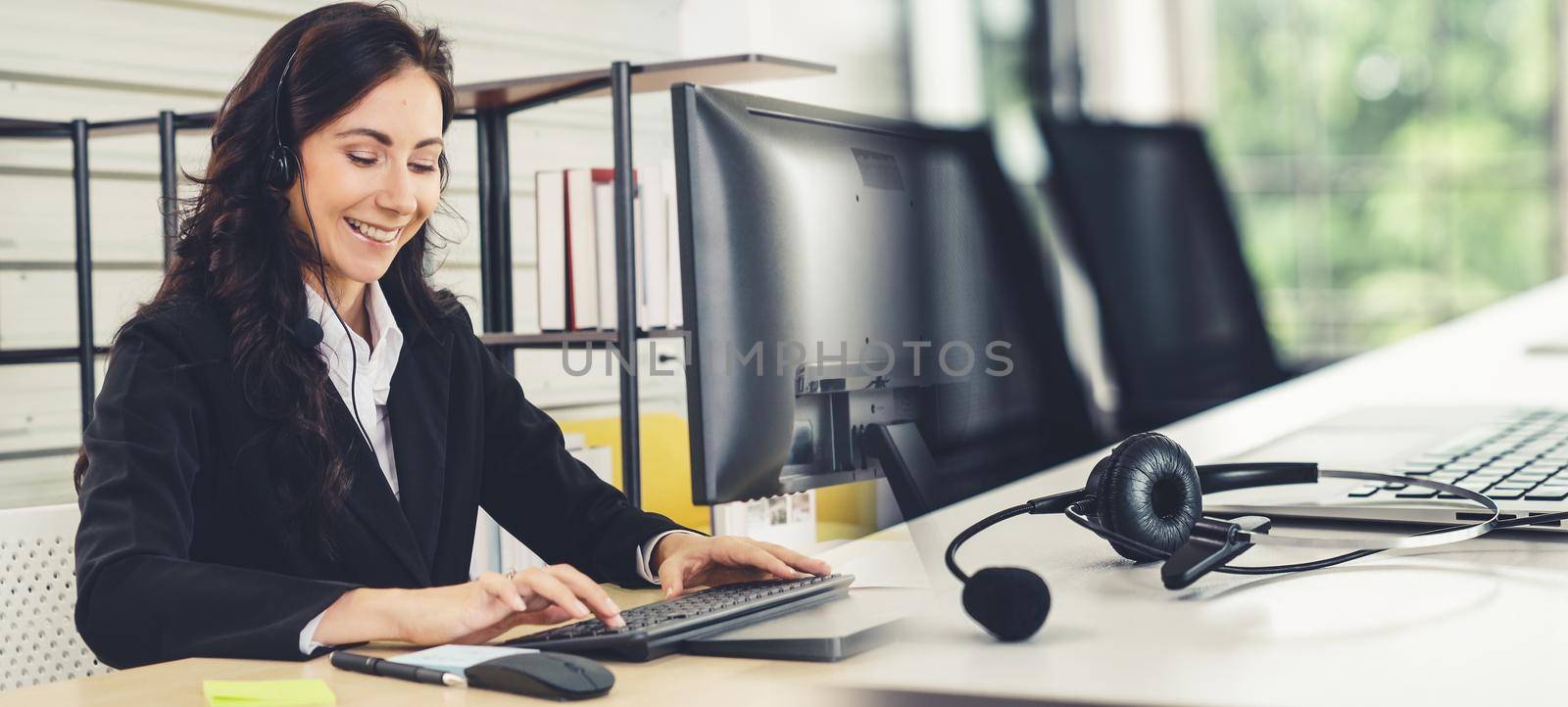 Business people wearing headset working in office to support remote customer or colleague. Call center, telemarketing, customer support agent provide service in broaden view .