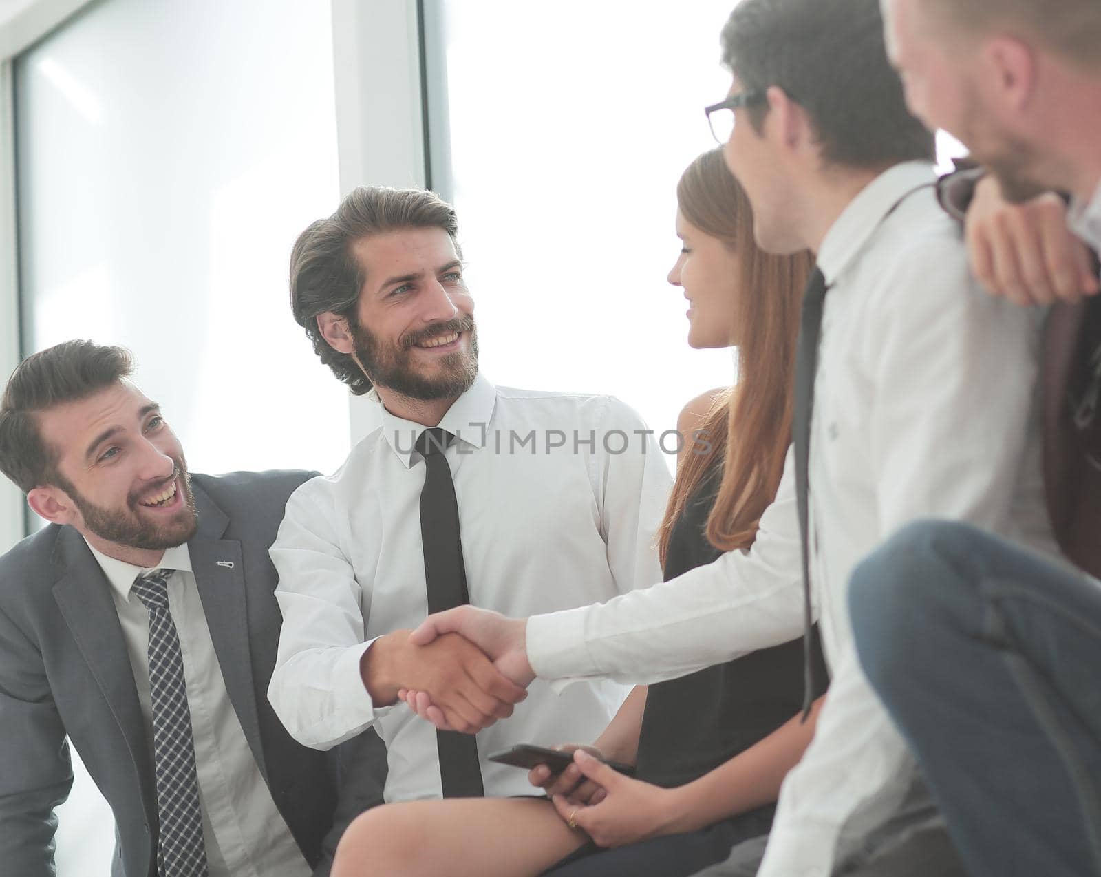 young business people shaking hands while sitting in the office lobby . business concept