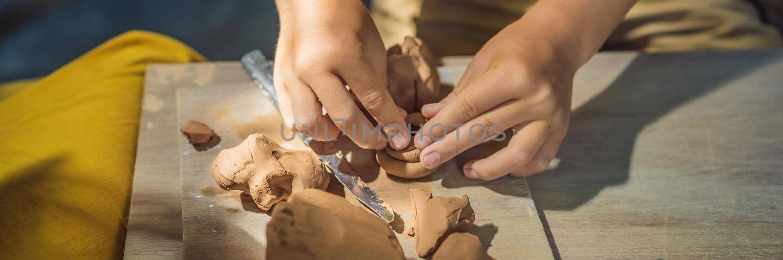mother and son doing ceramic pot in pottery workshop. What to do with children. Child friendly place BANNER, LONG FORMAT by galitskaya