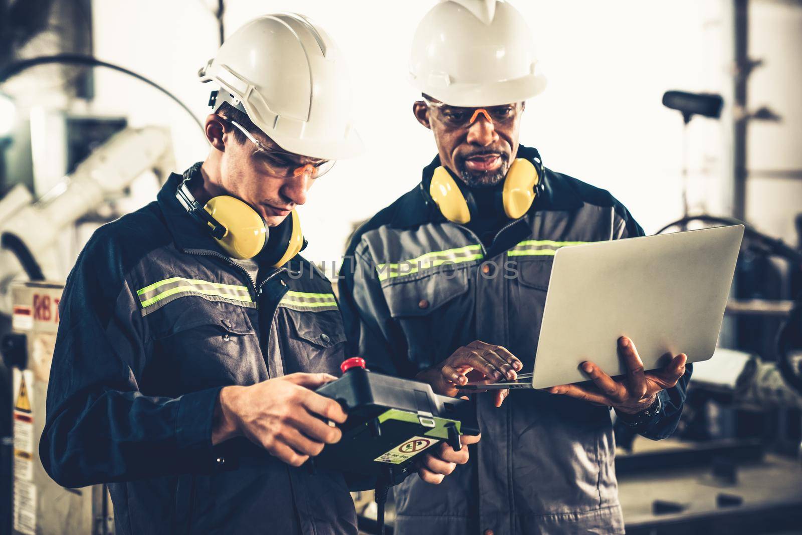 Group of factory job workers using adept machine equipment in a workshop by biancoblue