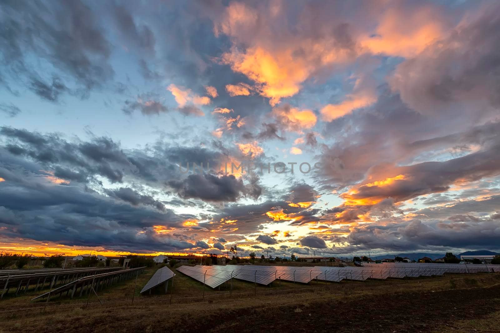 Amazing colorful sky after sunset over solar panels, with reflection