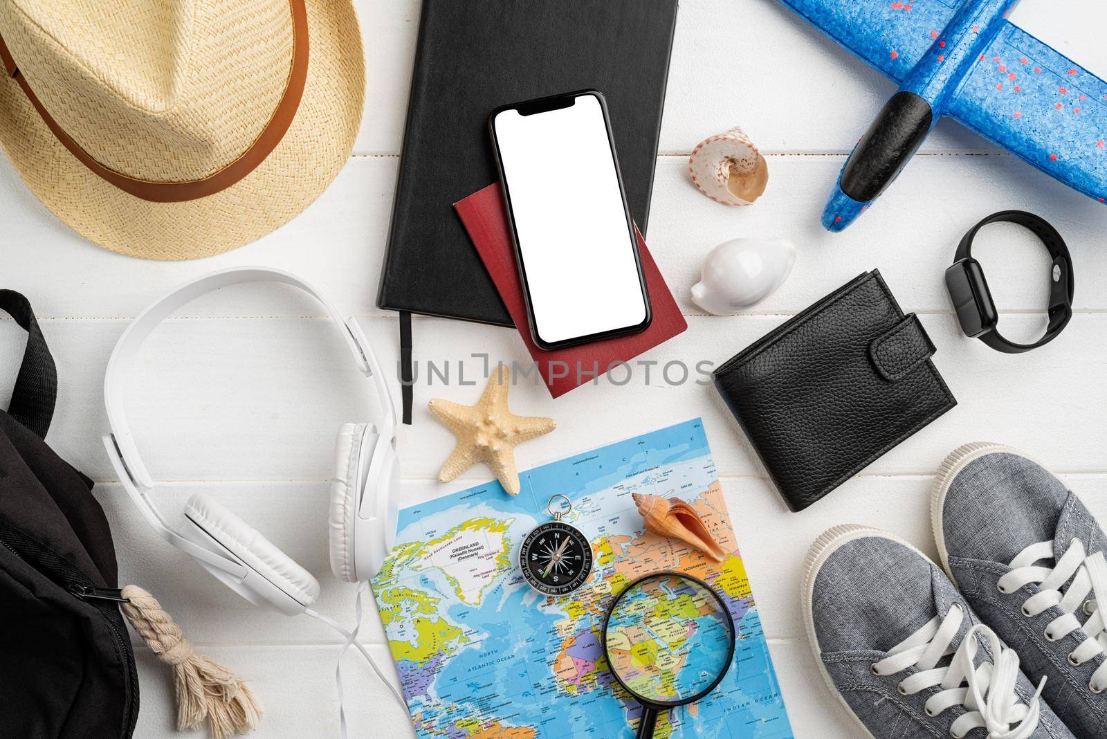 travel plan, trip and vacation, technology. Top view travel accessories with shoes, map, smartphone with mockup screen, hat. Copy space