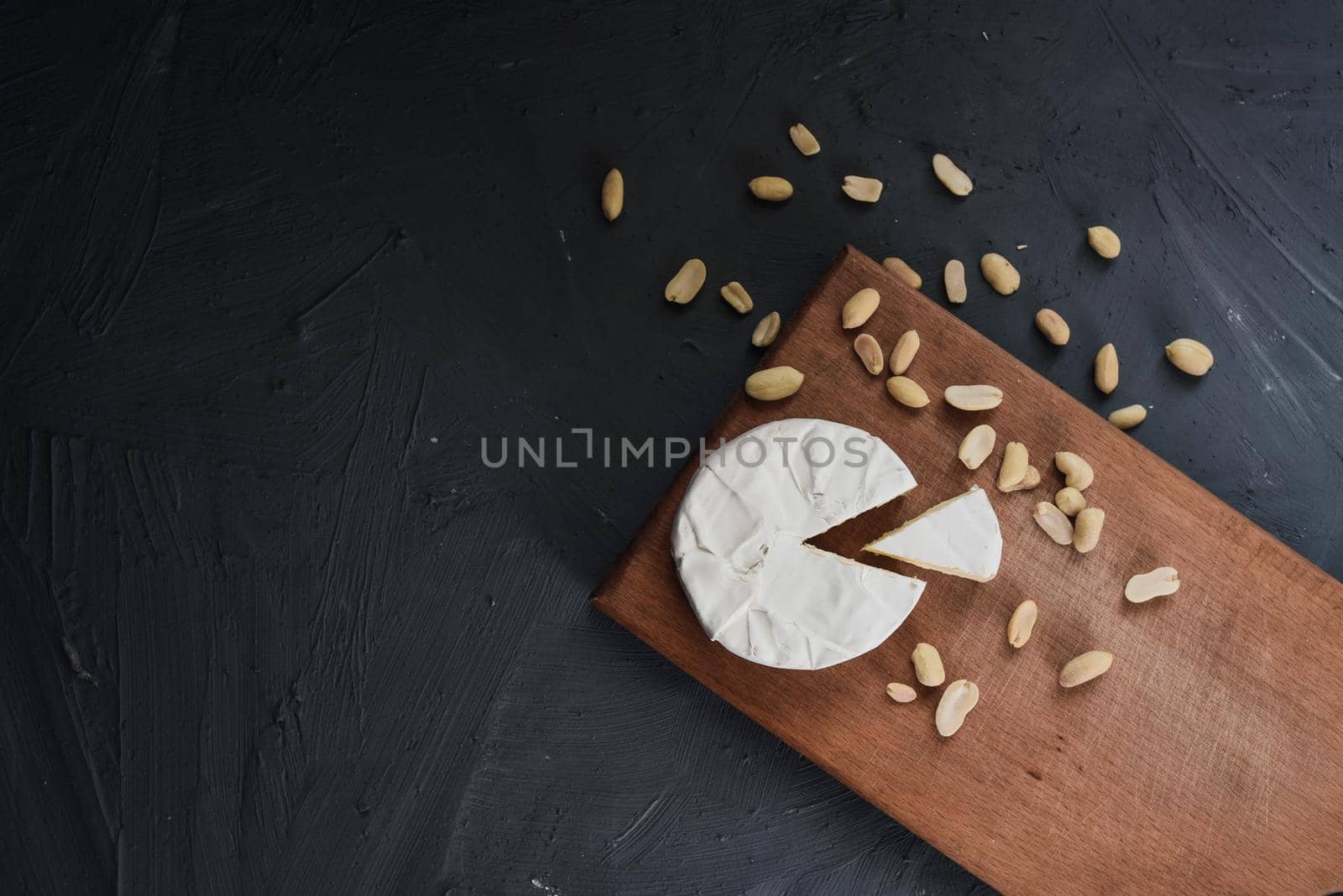 cheese camembert with mold and nuts on the wooden cutting board