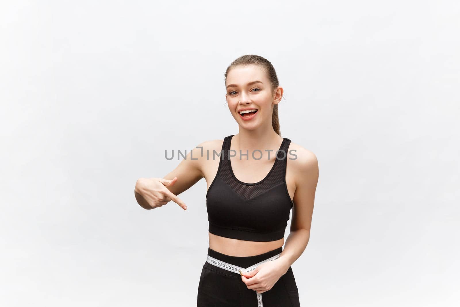 Portrait of attractive caucasian smiling woman with measuring tape isolated on white background