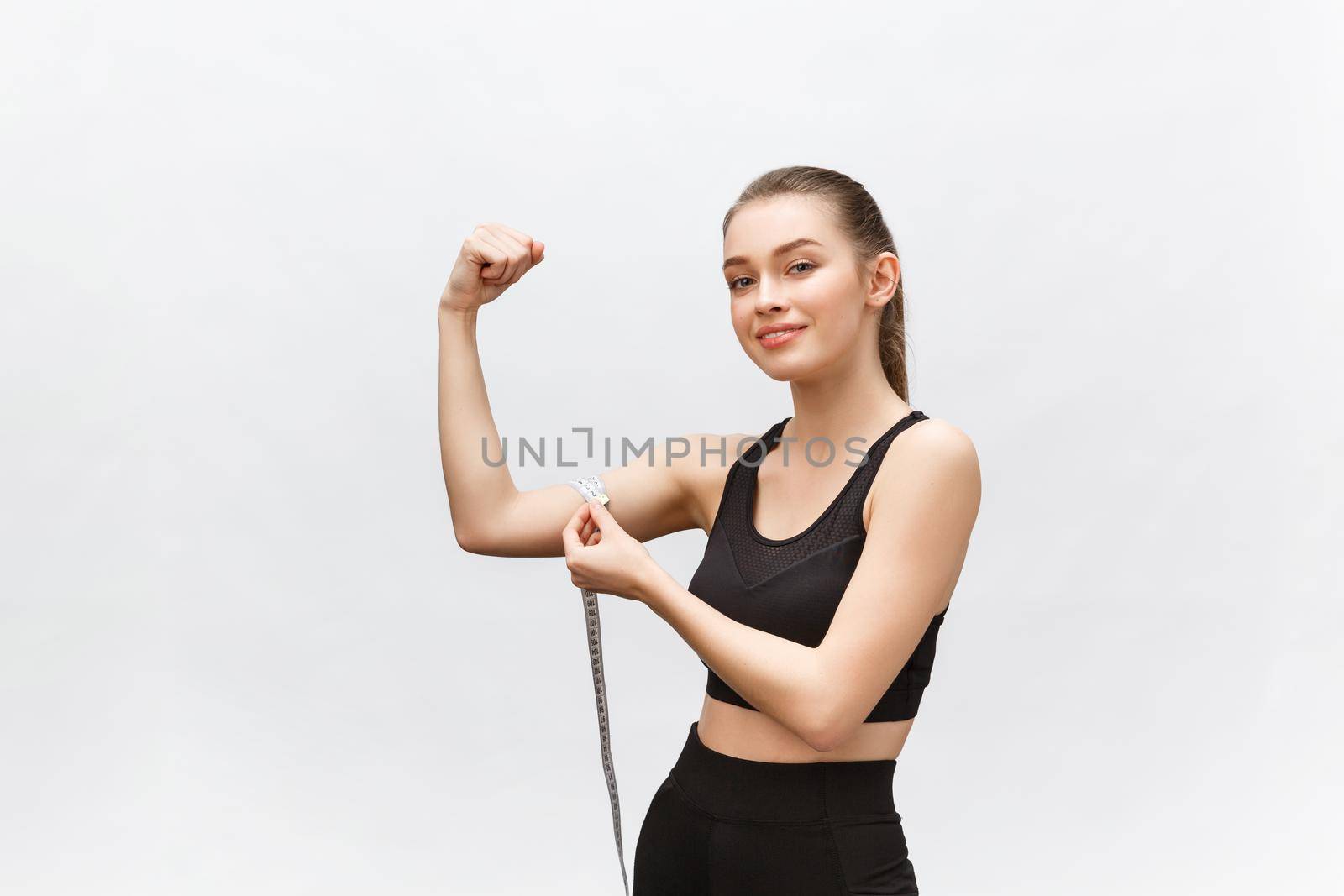 Happy slim woman with measuring tape on color background. Positive weight loss diet results. by Benzoix