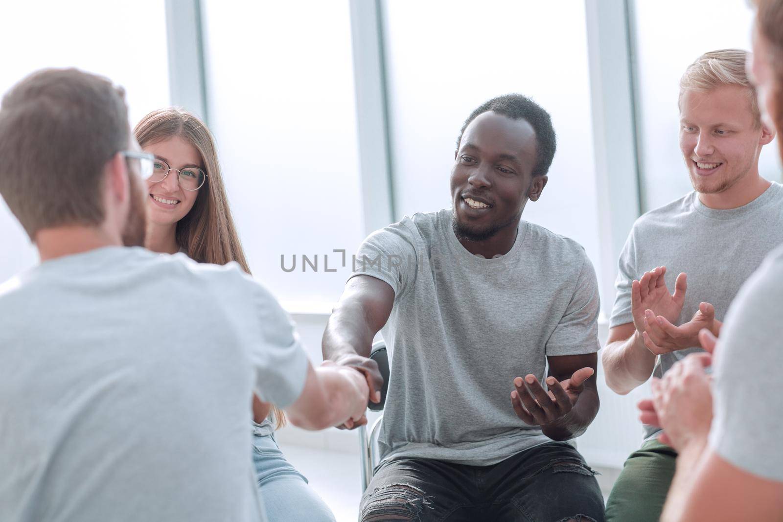 handshake of young people in a circle of like-minded people by asdf