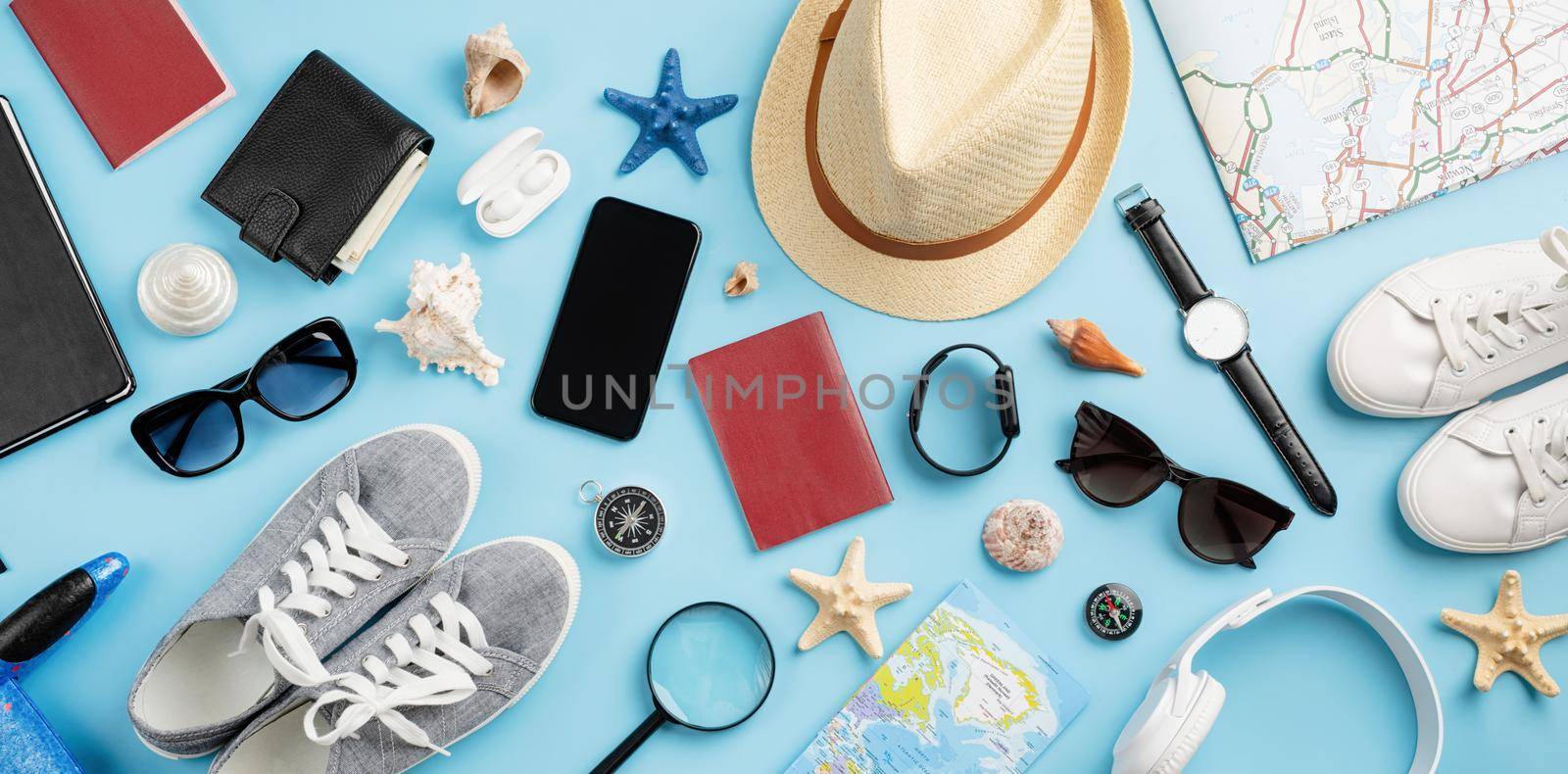 Top view travel accessories with shoes, map, smartphone with mockup screen, hat. Tourist essentials. by Desperada