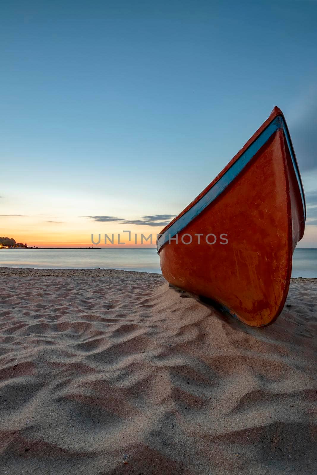 beauty morning with the lonely red boat on the sea beach. Vertical view