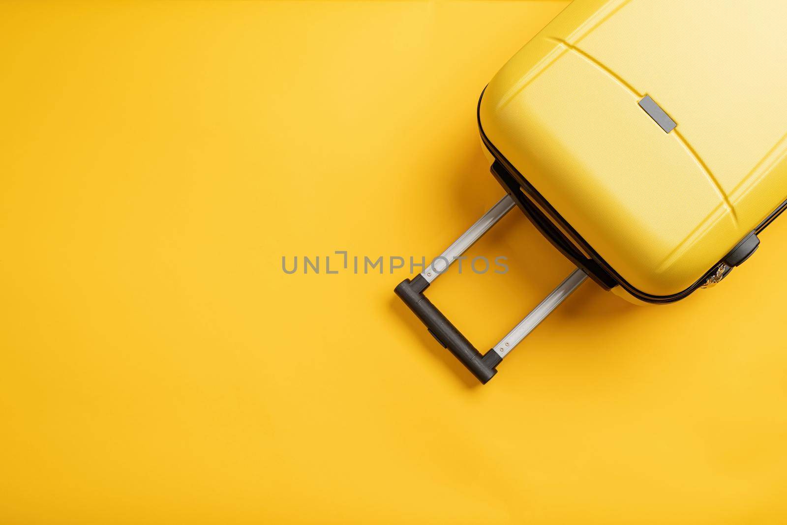 travel plan, trip and vacation, minimal. Top view yellow travel bag or suitcase on solid yellow background with copy space