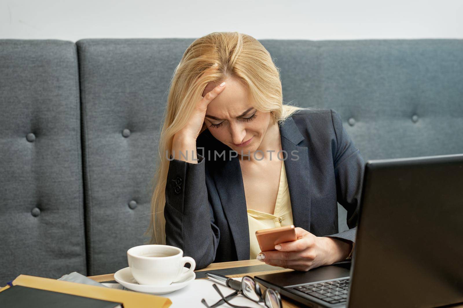 Woman looking upset while using smartphone. by okskukuruza