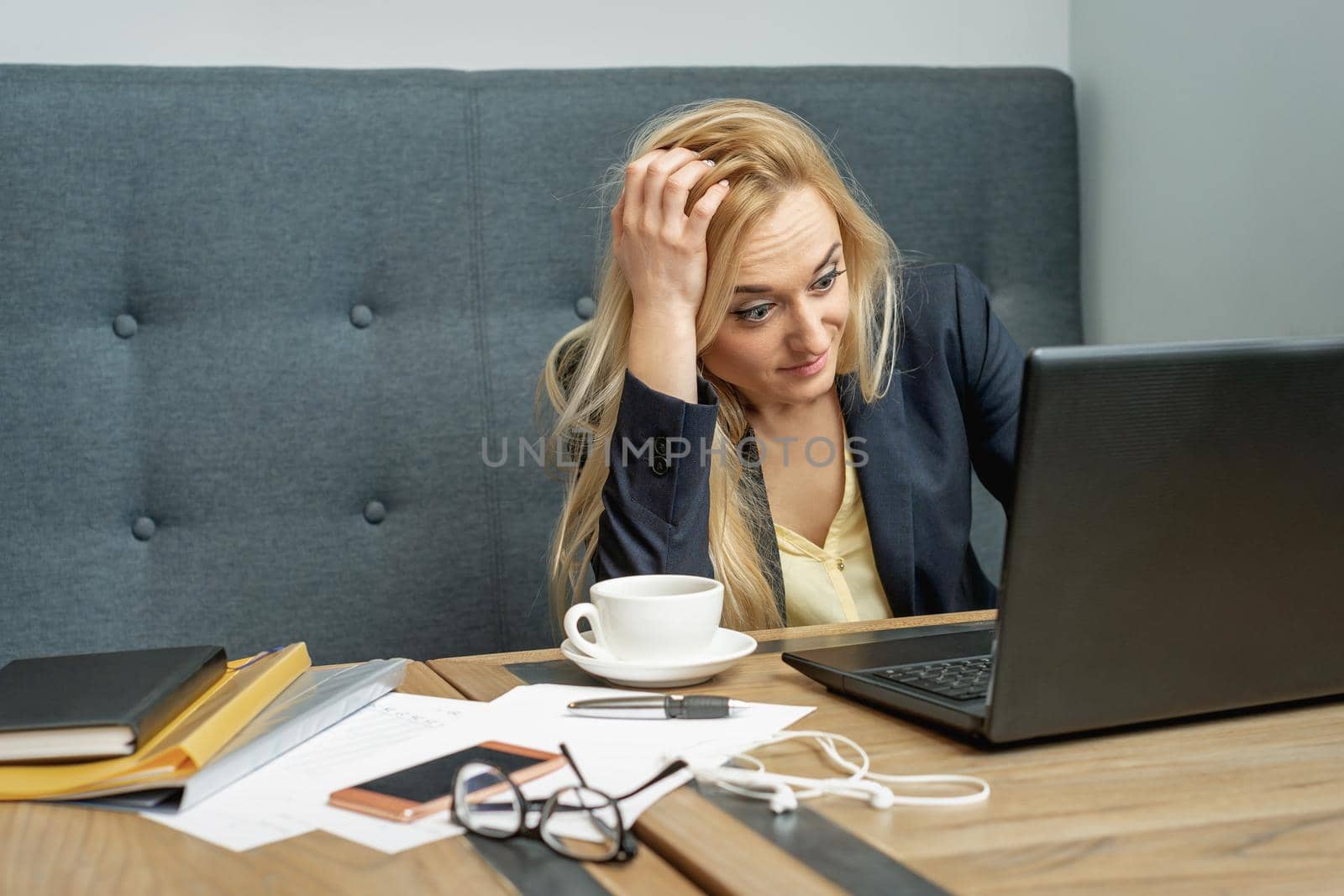 Woman looking surprised while using the laptop at the workplace at home.