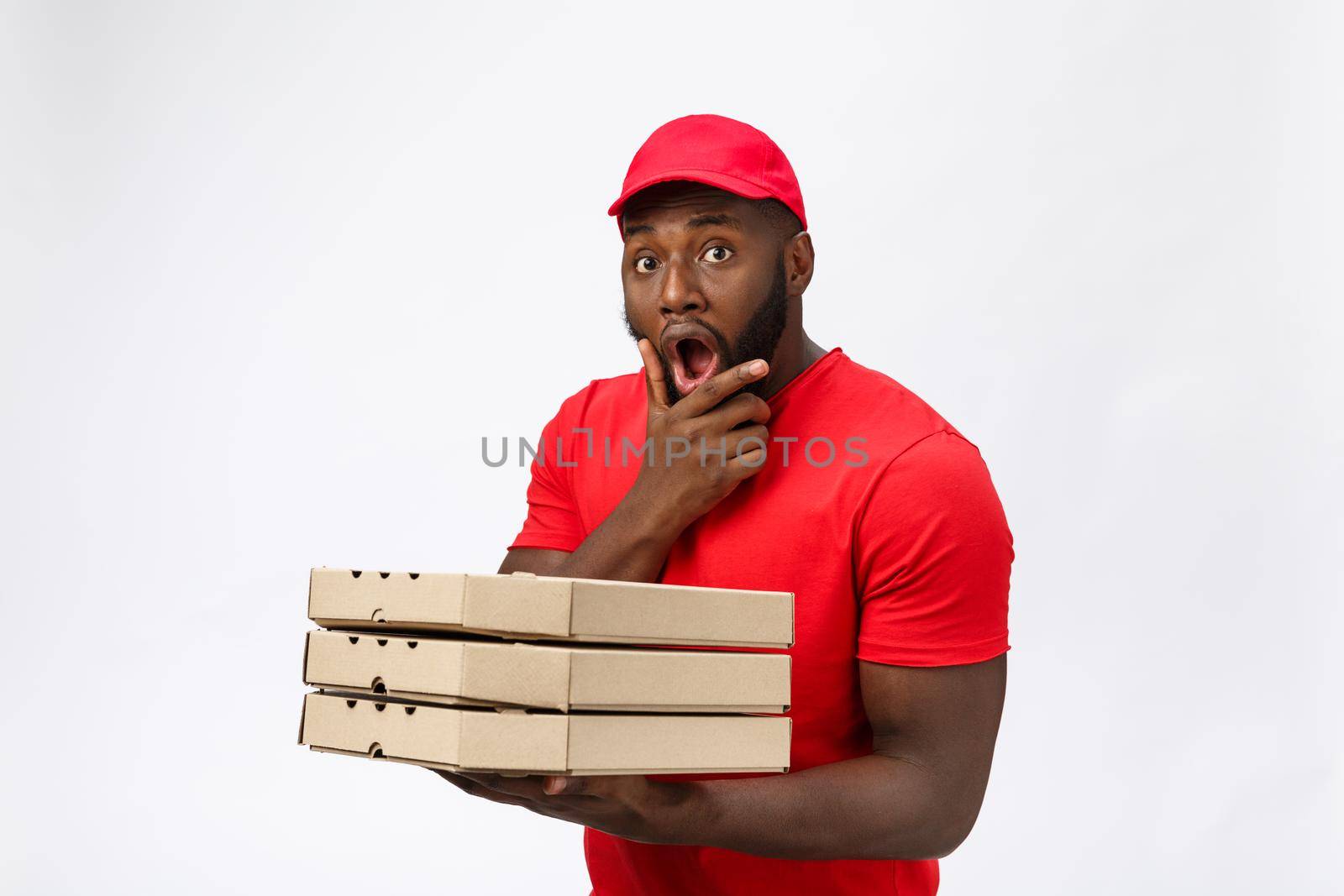 Delivery Concept - Portrait of Handsome African American Pizza delivery man. Isolated on Grey studio Background. Copy Space by Benzoix