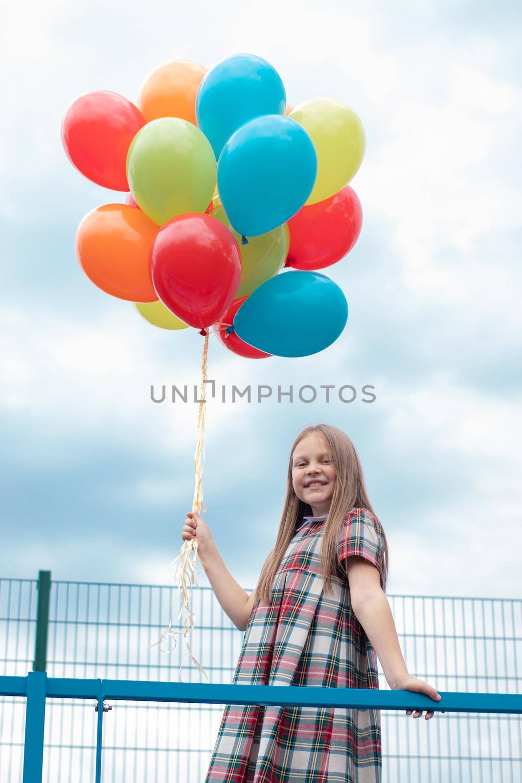Teenage girl with colorful helium air balloons having fun outdoors. Tween Party. enjoying summer.