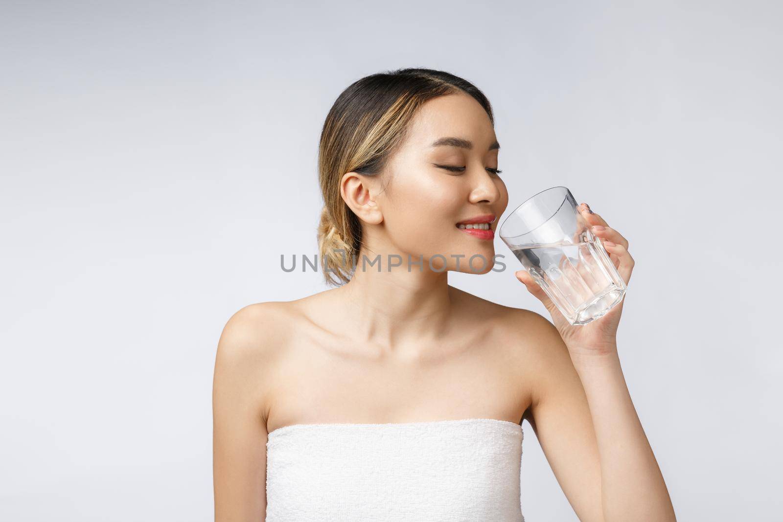 relaxed young smiling woman drinking clean water. by Benzoix