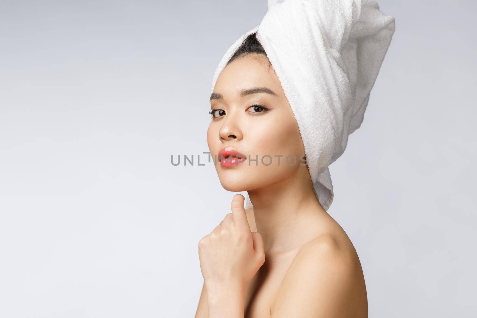 Sided portrait of Asian beautiful smiling girl with short hair showing her healthy skin on the isolated white background.