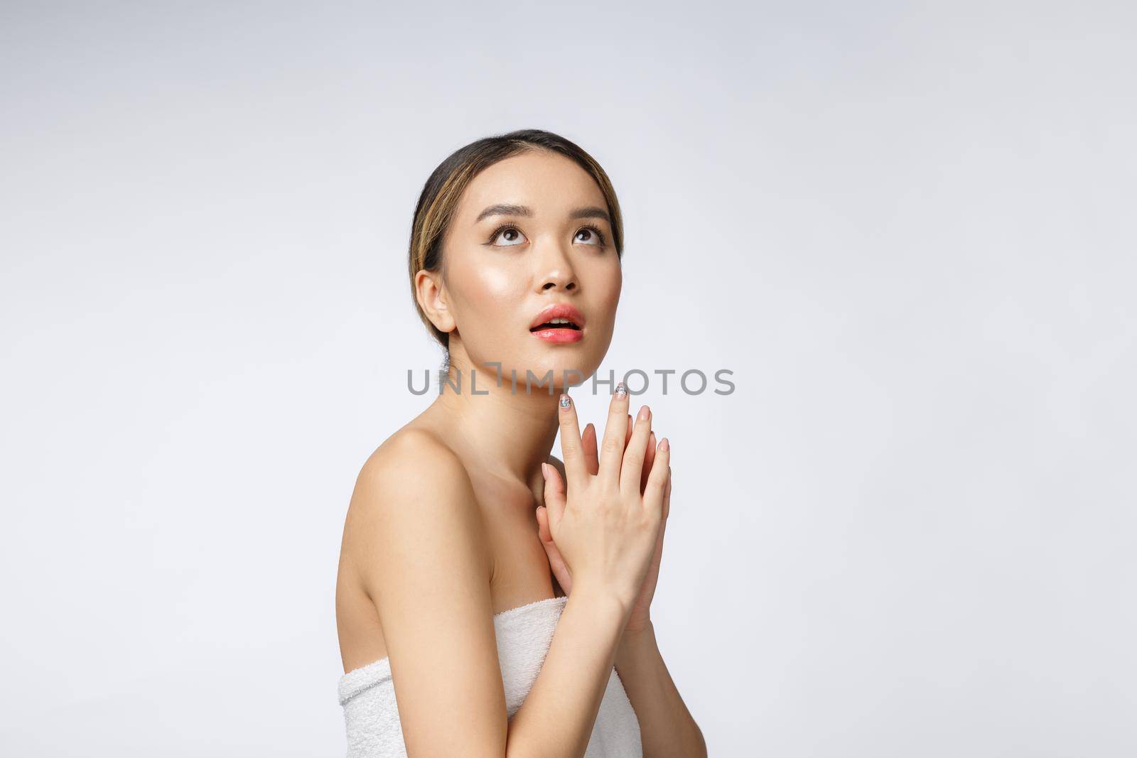 Sided portrait of Asian beautiful smiling girl with short hair showing her healthy skin on the isolated white background.