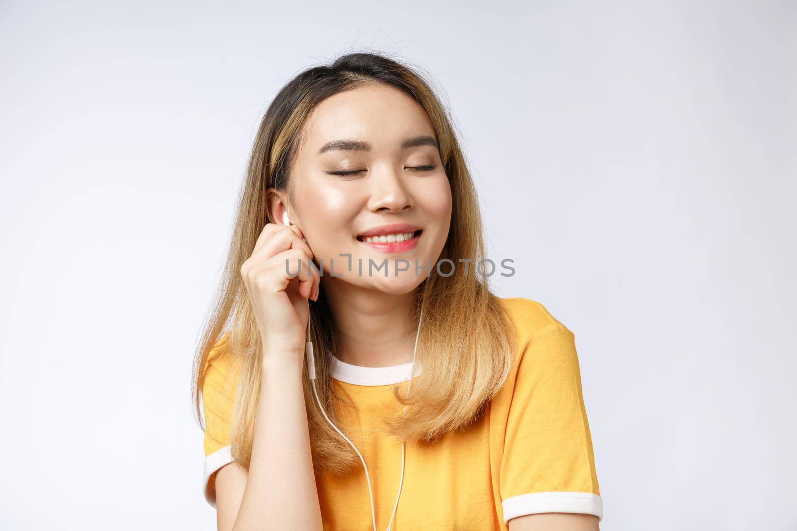 Portrait of happy Asian young woman listen to music with headphone