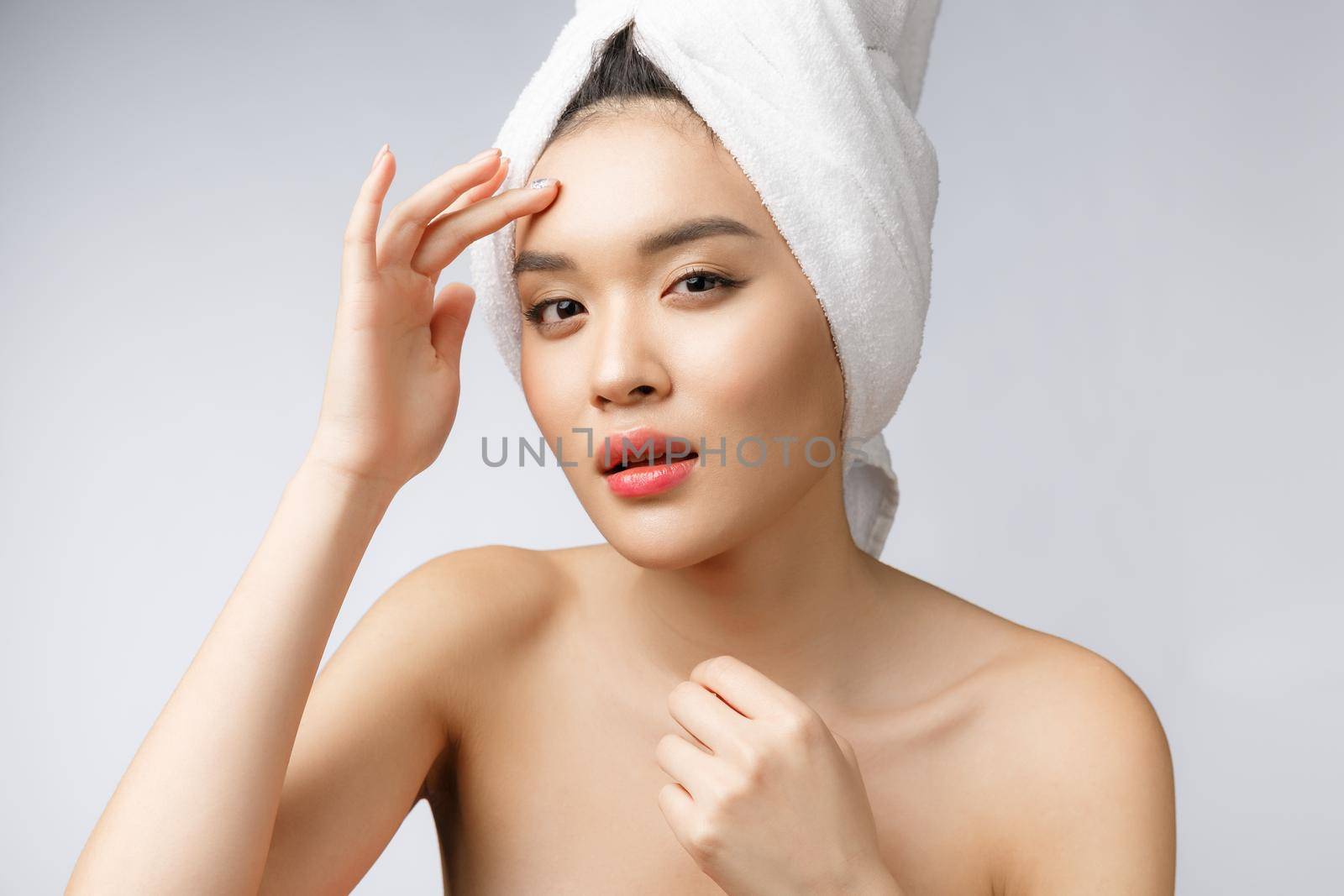 Asian woman looking at pimple on face. Young Woman try to remove her pimple. Woman skin care concept. Isolated on white background.