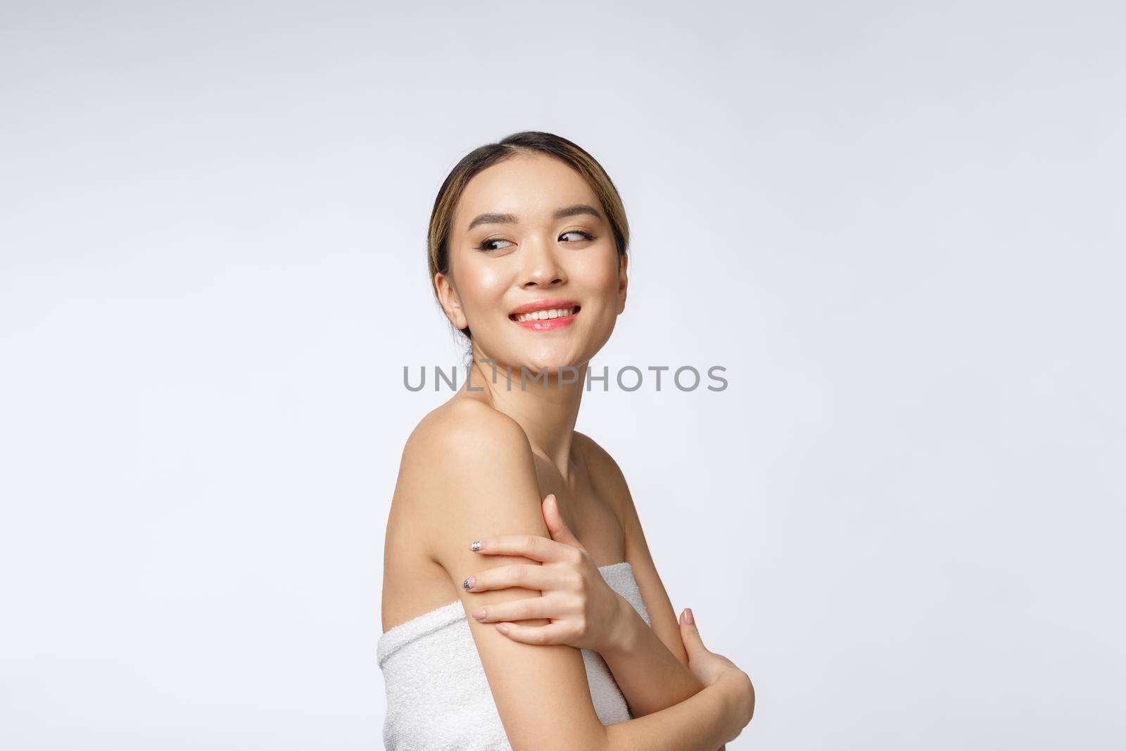 Sided portrait of Asian beautiful smiling girl with short hair showing her healthy skin on the isolated white background.