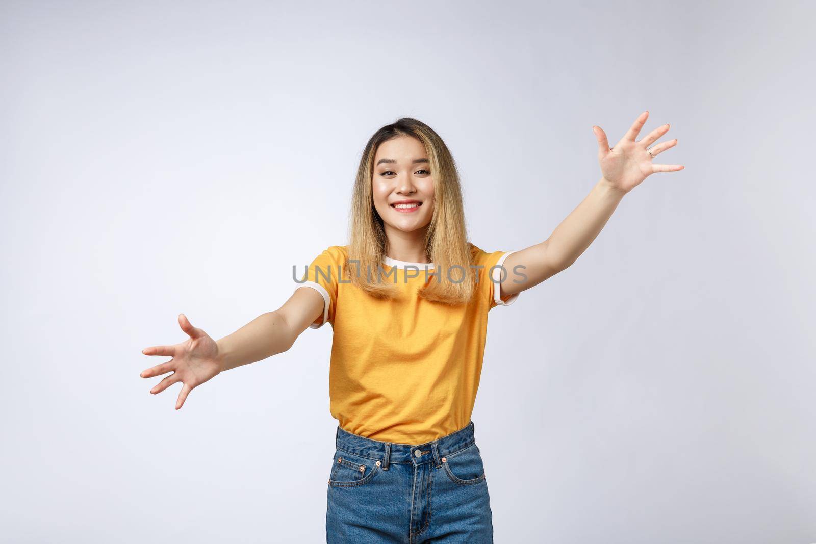 Closeup portrait of pretty young woman motioning with arms to come and give her a bear hug, isolated on white background. Positive emotion facial expression feeling, signs symbols, body language