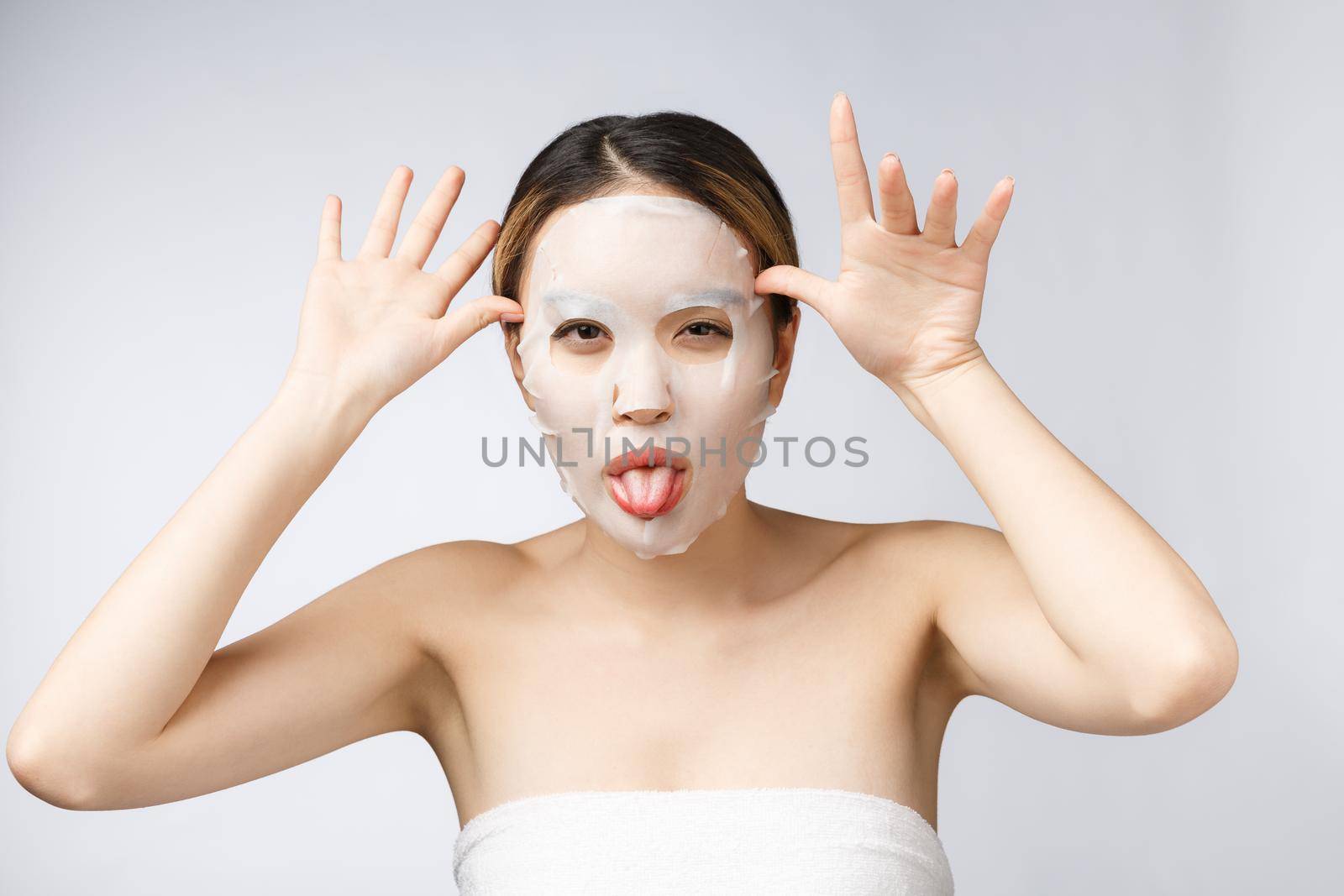 Spa, healthcare. Asian girl with a cosmetic mask isolate on white. by Benzoix