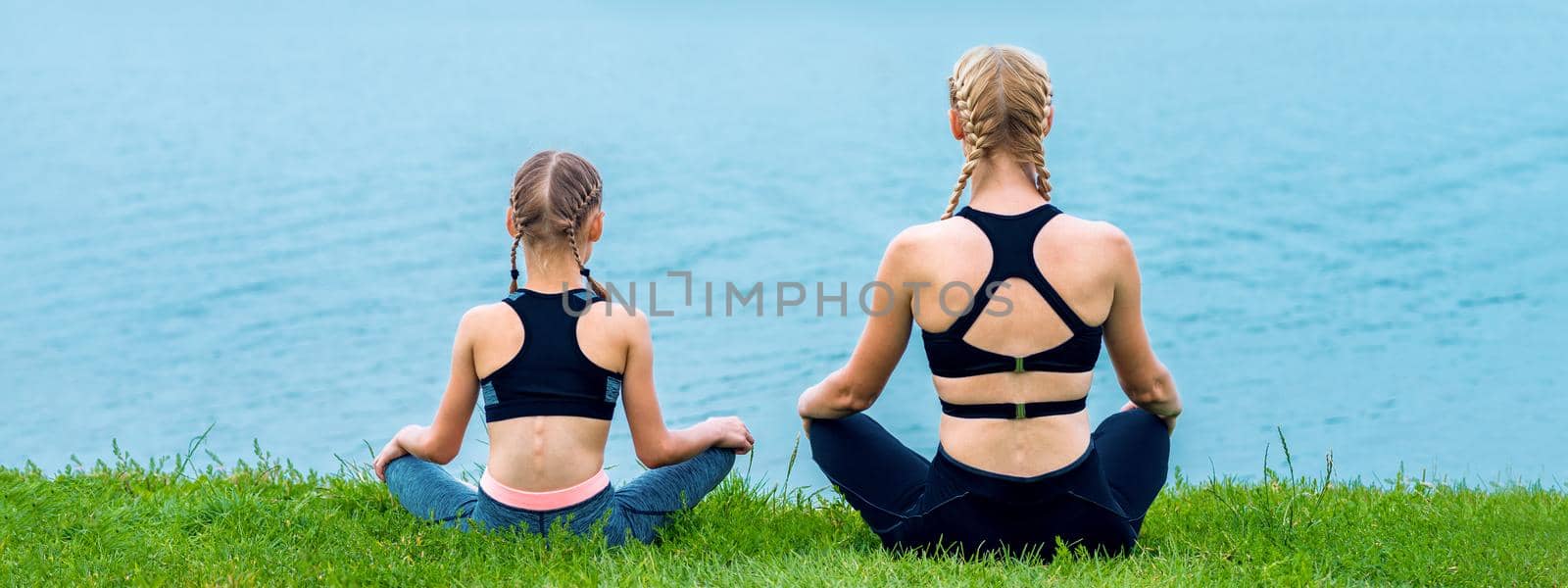 Mother and daughter doing yoga exercises by okskukuruza